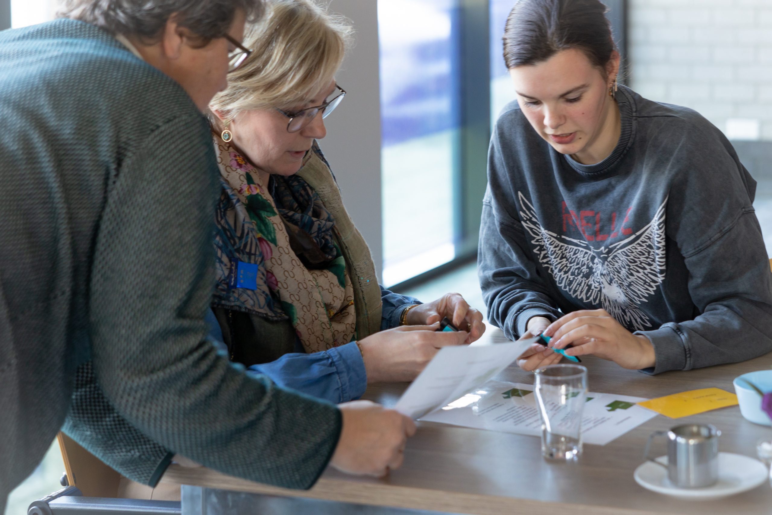 Suzan en deelnemers werken samen aan een opdracht tijdens een workshop